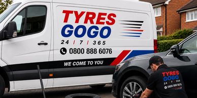 Mobile tyre fitting service with van and technician at work.