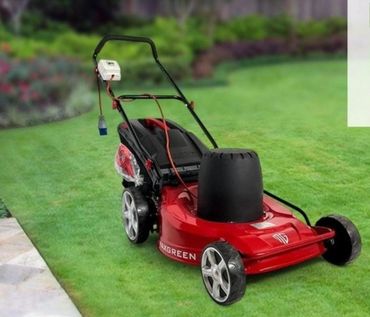 Red lawn mower with a unique black cylindrical attachment on a green lawn.