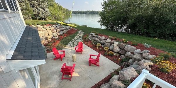 Relax & enjoy the lake view from your Adirondack chair on the lakeside patio with native plantings.
