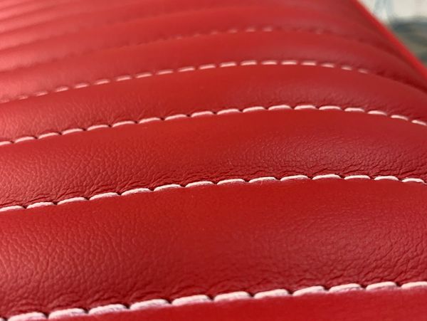 Red leather bench seat with white stitching