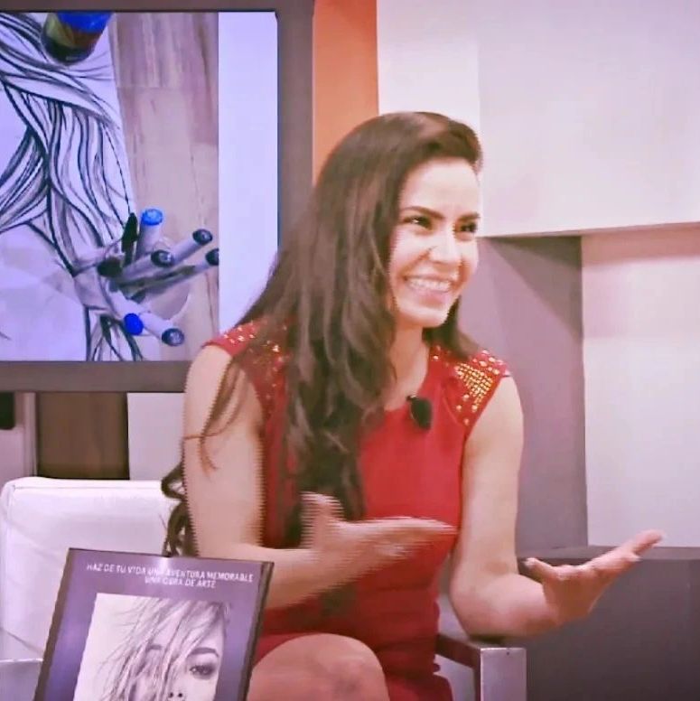 Mujer sonriente con vestido rojo en entrevista o presentación.