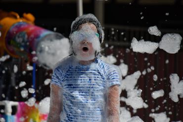 Foam cannon and girl covered in bubbles
