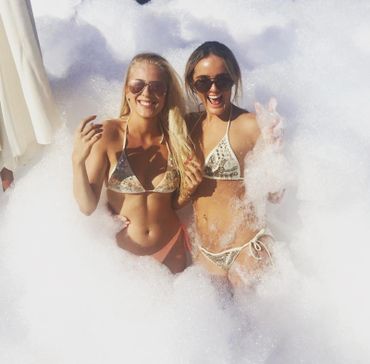 Women taking a foam photo and smiling