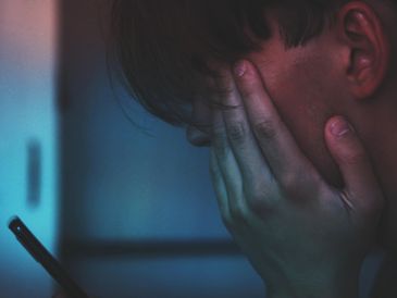 Close-up view of a person covering their eyes with their hand
