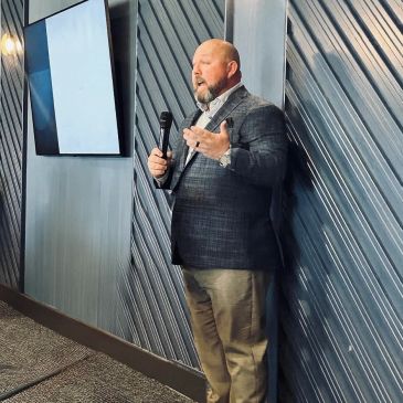 Man giving a presentation with a microphone in a modern room.