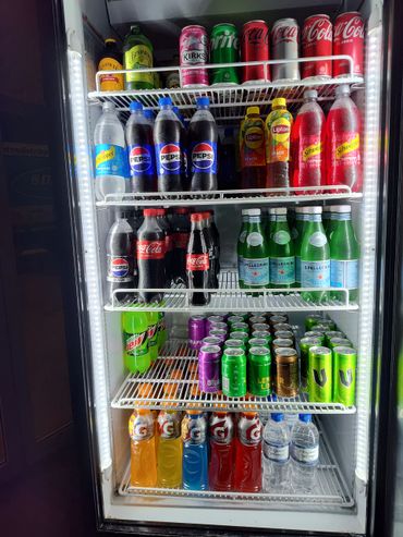 A fridge stocked with various sodas, waters, and sports drinks.