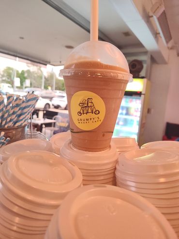 A chocolate smoothie from Grumpy's Wharf Cafe on a stack of white cup lids.