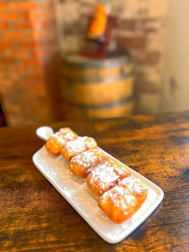 A white plate topped with four powdered donuts.