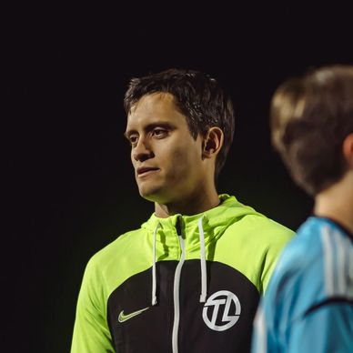 Man in a neon green and black sports jacket looking to the side.