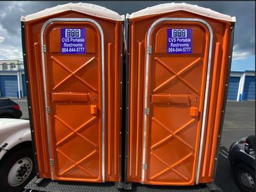 Two orange portable restrooms with CVS Portable Restrooms signage.