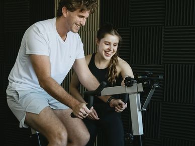 Man and woman exercising together indoors.