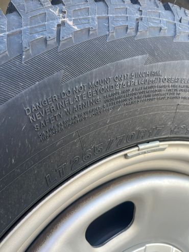 Close-up of a tire showing safety warnings and tire size information.