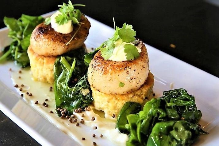 Floribbean Spiced Scallops, Corn Souffle, Citrus Beurre Blanc, Wilted Spinach, Toasted Coriander pod