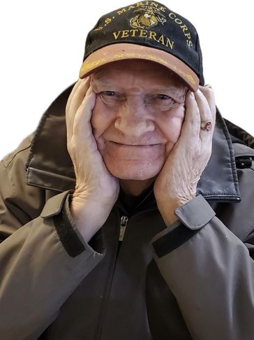Elderly man wearing a U.S. Marine Corps veteran cap and jacket, smiling gently.