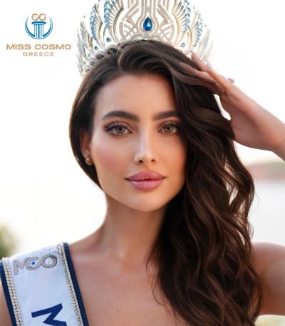 Beauty queen wearing a jeweled crown and sash.