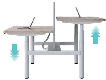 Adjustable height dual workstation desk with two laptops and divider.