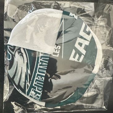 A Philadelphia Eagles face mask in plastic packaging.