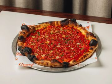 Pizza with charred crust and tomato topping.