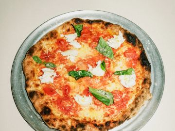 Neapolitan pizza with tomatoes, basil, and mozzarella.