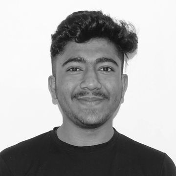 Young man smiling in a black graphic t-shirt against a plain white background.