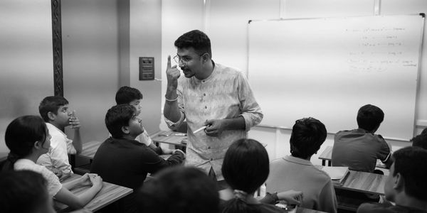 Teacher passionately explaining a concept to attentive students in a classroom.