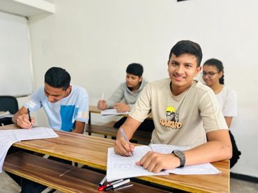 Students happily working on assignments in a classroom.