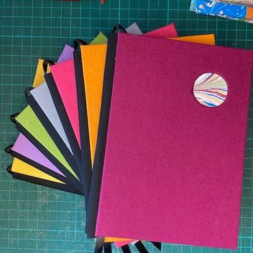 Colourful handmade notebooks with black spine and ribbon marker
