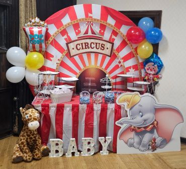 Circus-themed party dessert table setup with balloons and decorations.