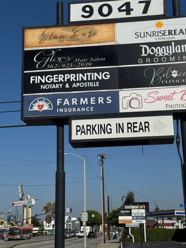 A multi-business signboard with various services and parking info.