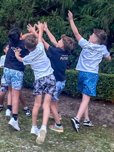 A group of boys jumping and reaching up outdoors.