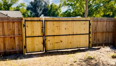 New wooden fence gate under a sunny sky.