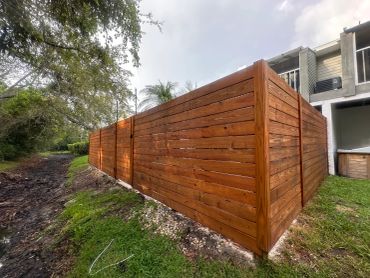 Wooden privacy fence around a house backyard.