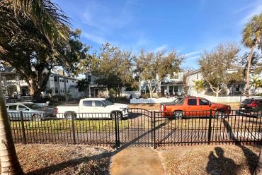 Residential neighborhood with parked vehicles and trees.