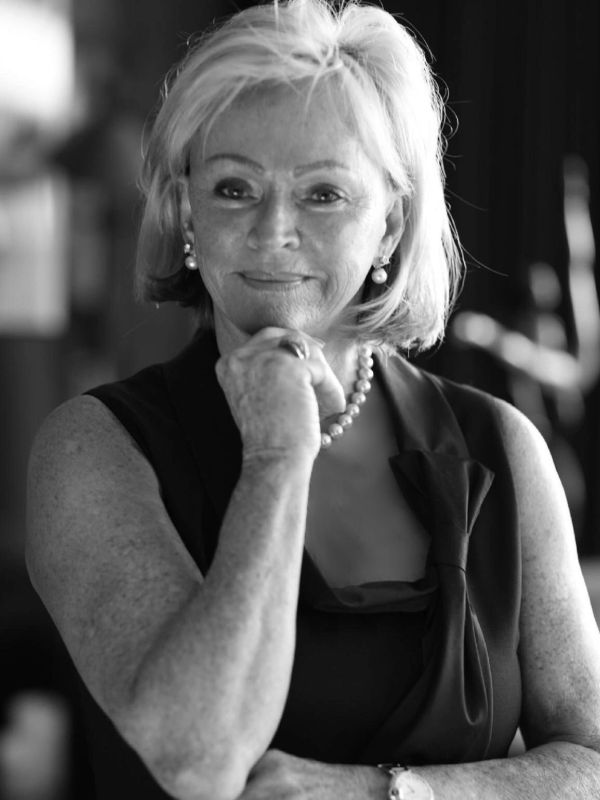 Confident older woman with pearls in black and white.