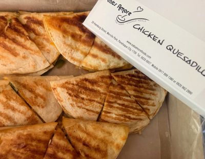 Grilled chicken quesadilla slices in a takeout box.