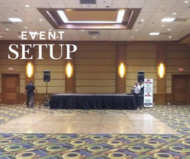 Montaje de evento con escenario y altavoces.
