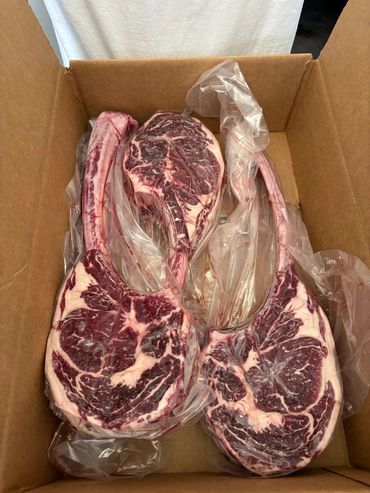 Three large tomahawk ribeye steaks.