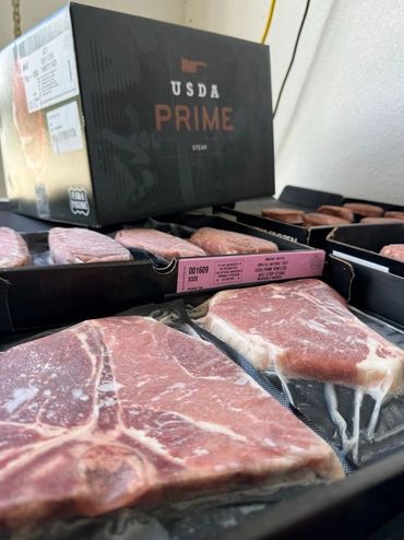 Vacuum-sealed USDA Prime steaks packaged in black boxes ready for sale.