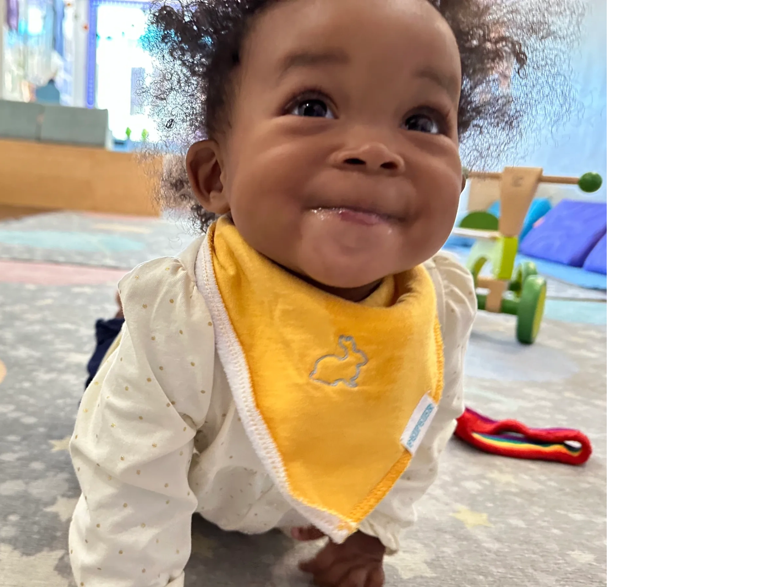 smiling infant with yellow Bunny bib in the studio in Brooklyn