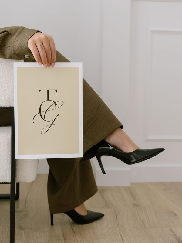Person holding a framed print with initials T and G.