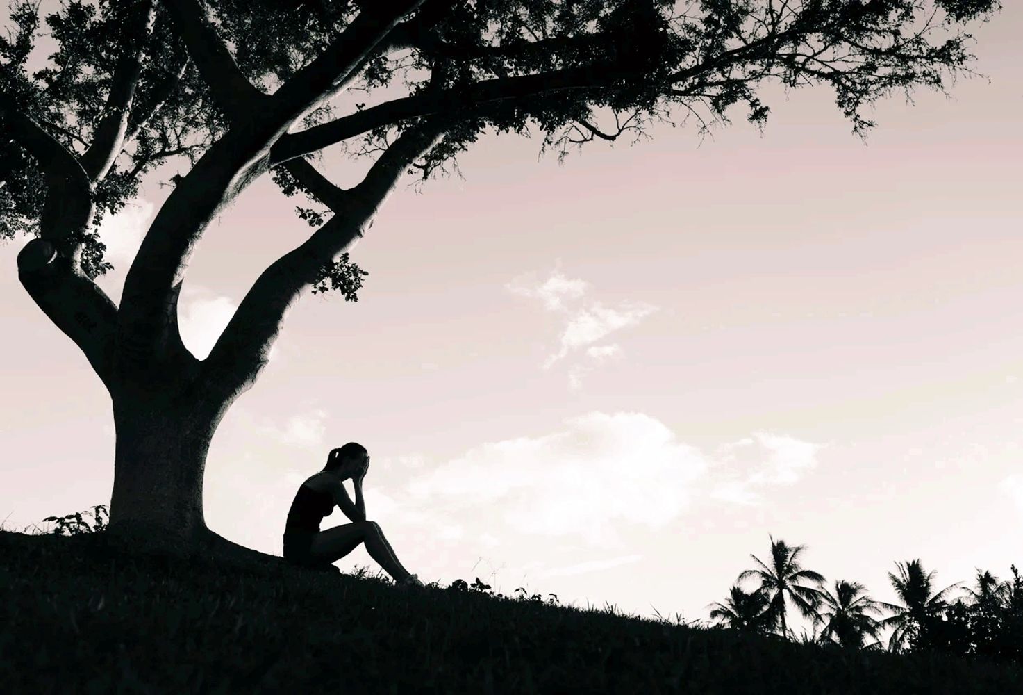 Woman sitting under a tree.