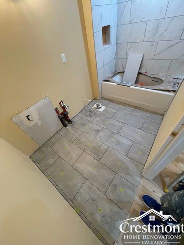 Bathroom under renovation with newly installed floor tiles and bathtub. Basement concrete crack repaired.