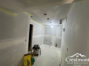 Room under renovation with drywall and construction tools visible.