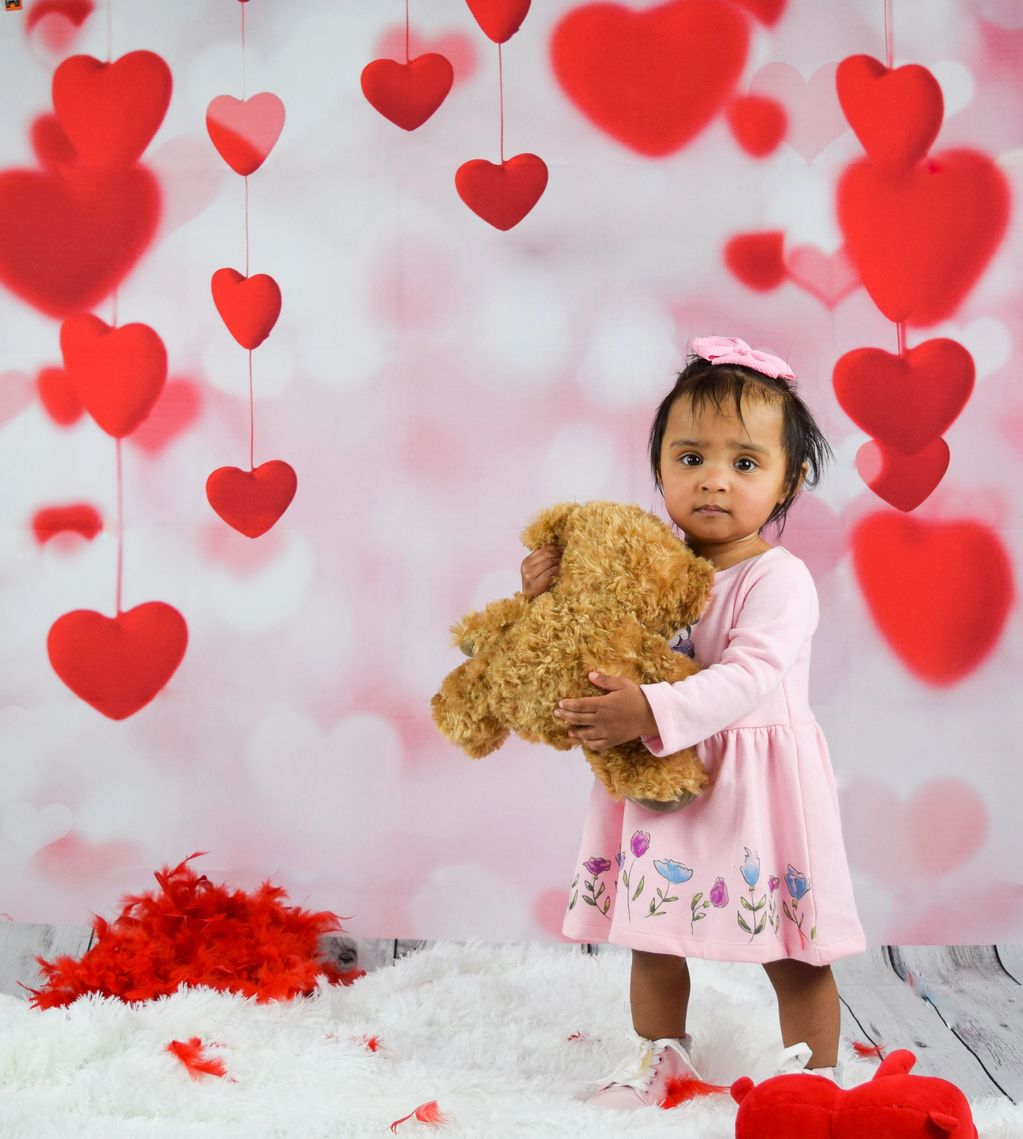 Beautiful little girl. Valentine's Day photoshoot! Girl and a little red bear. Hearts. Love. Girl.