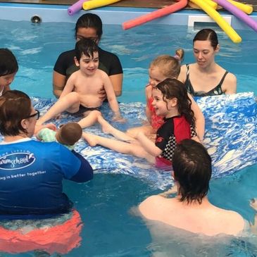 Parents and their children enjoying swimming lessons