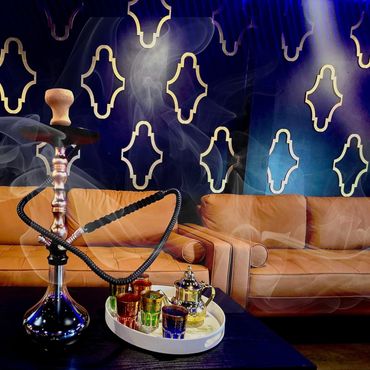 Elegant hookah and tea set in a stylish lounge with cozy sofas.
