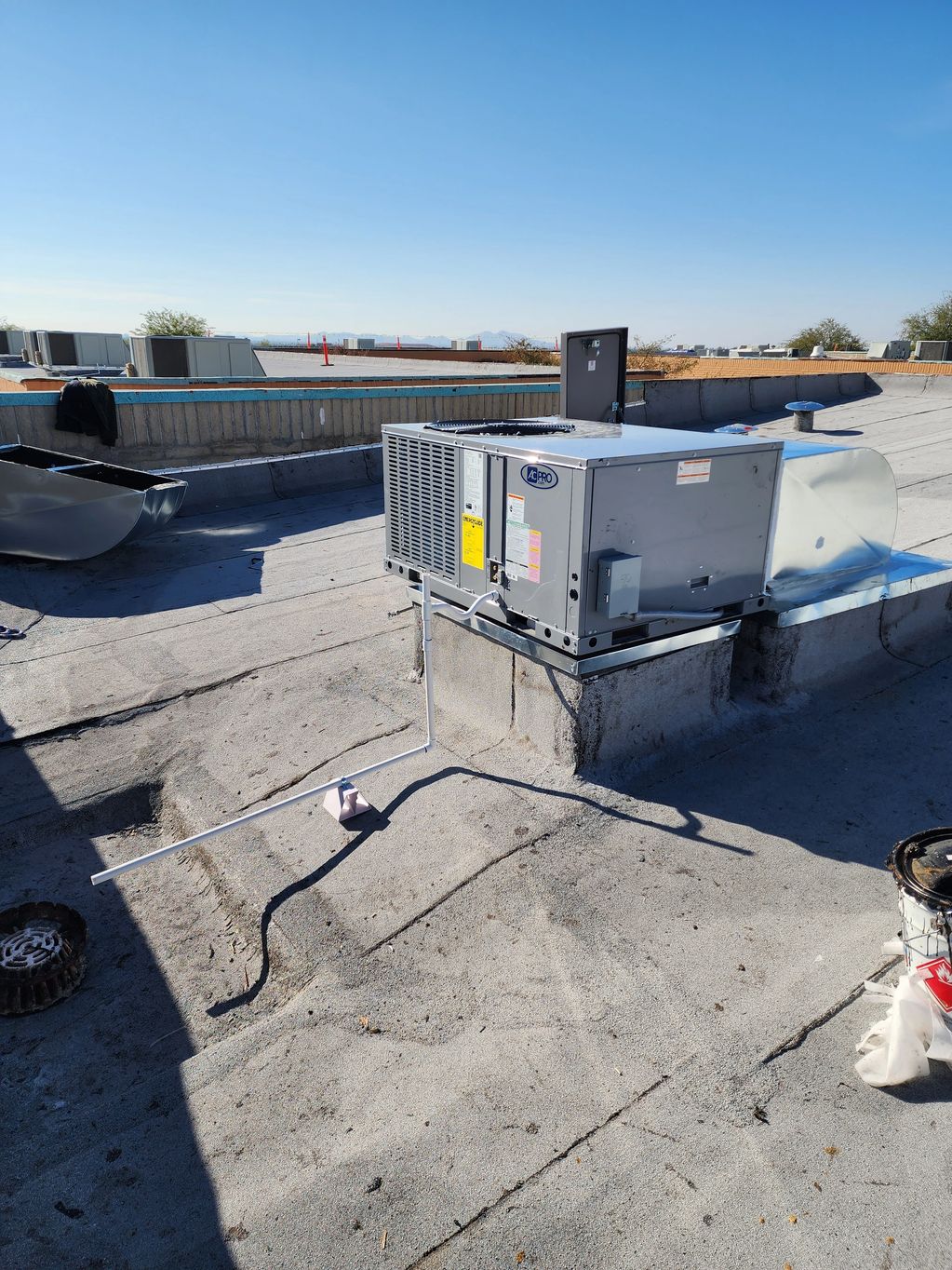 Commercial rooftop HVAC unit under clear blue sky.