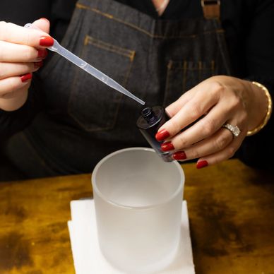 Person using a dropper to add liquid into a container.