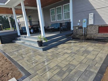 Newly paved patio with steps leading to a covered porch area.