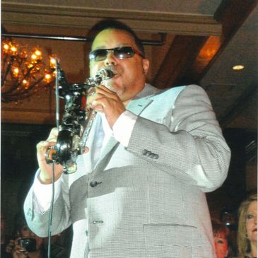 A Person in a White Suit With a Saxophone